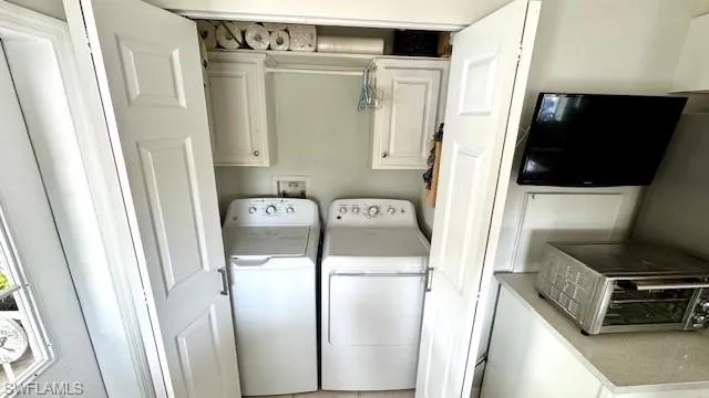 Clothes washing area inside hone with cabinets and independent washer and dryer