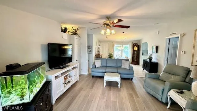 Living room with ceiling fan and light wood-type flooring