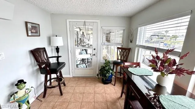 Living area with a textured ceiling and light tile patterned flooring