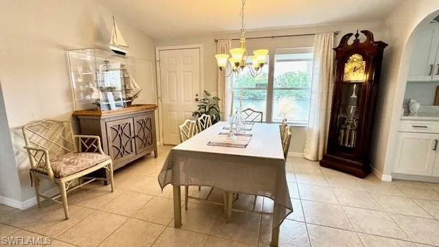 Dining room with light tile patterned flooring and a notable chandelier