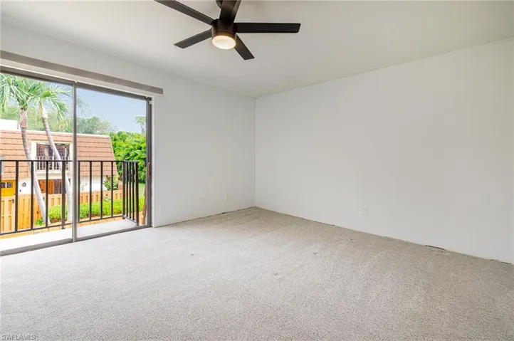 Room featuring wall-to-wall carpeting, white painted walls, and a ceiling fan with integrated lighting