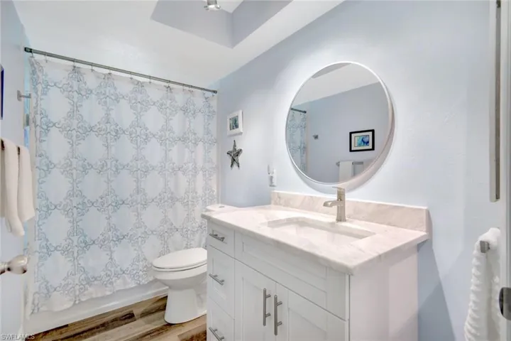 Bathroom featuring hardwood / wood-style floors, vanity, and toilet