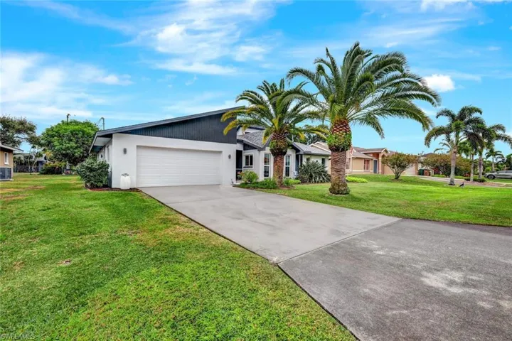 Single story home with a garage and a front yard