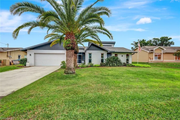 Ranch-style house featuring a garage and a front lawn