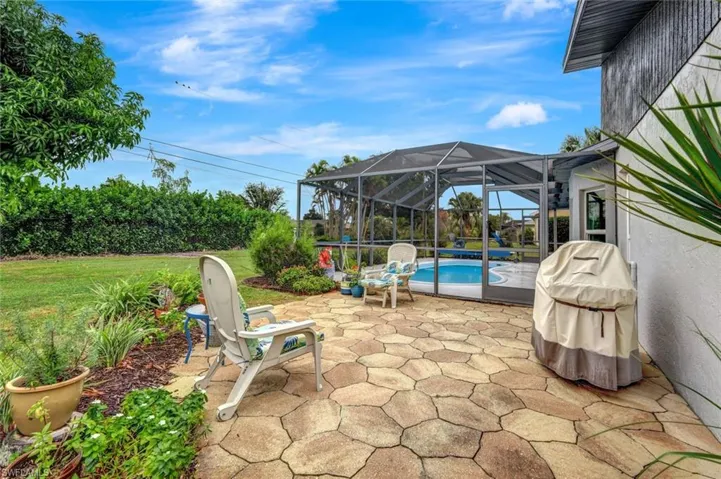View of patio featuring area for grilling and a lanai