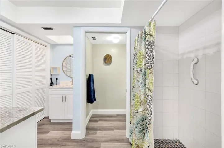 Bathroom featuring hardwood / wood-style flooring, vanity, and walk in shower