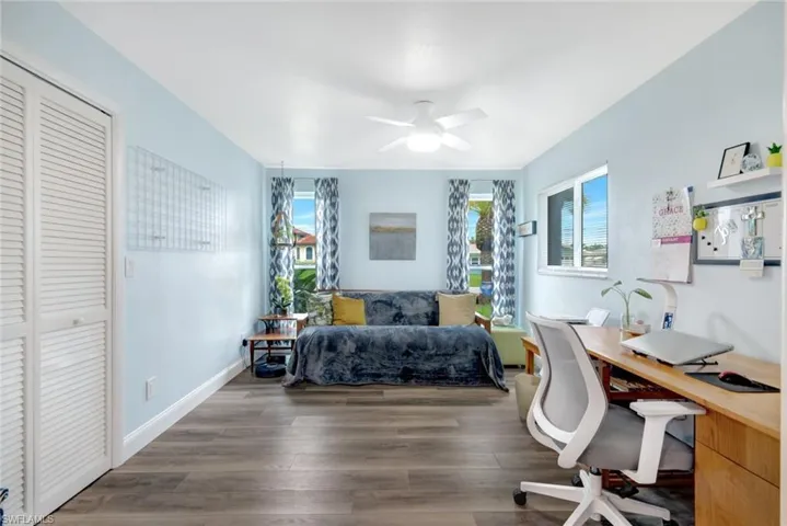 Bedroom featuring ceiling fan, a closet, and dark hardwood / wood-style flooring