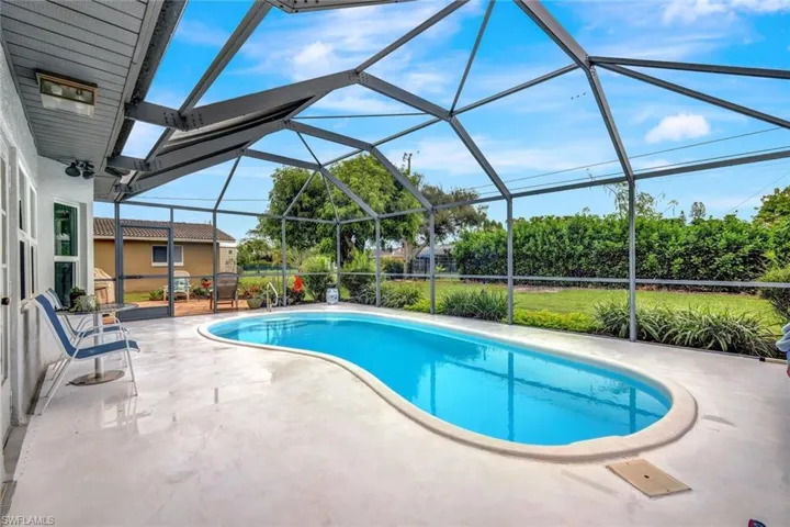 View of pool featuring glass enclosure and a patio