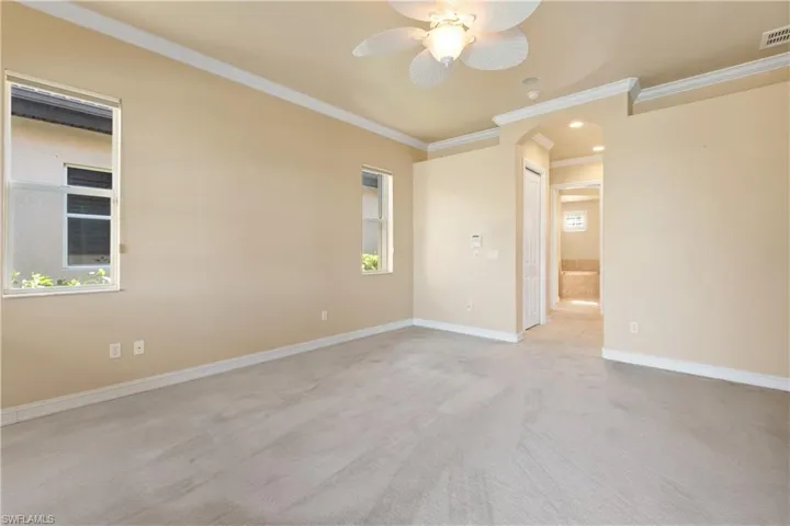 Unfurnished room featuring ornamental molding, light carpet, and ceiling fan