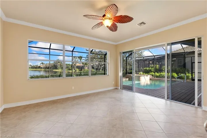 Tiled spare room featuring ornamental molding, a water view, and ceiling fan