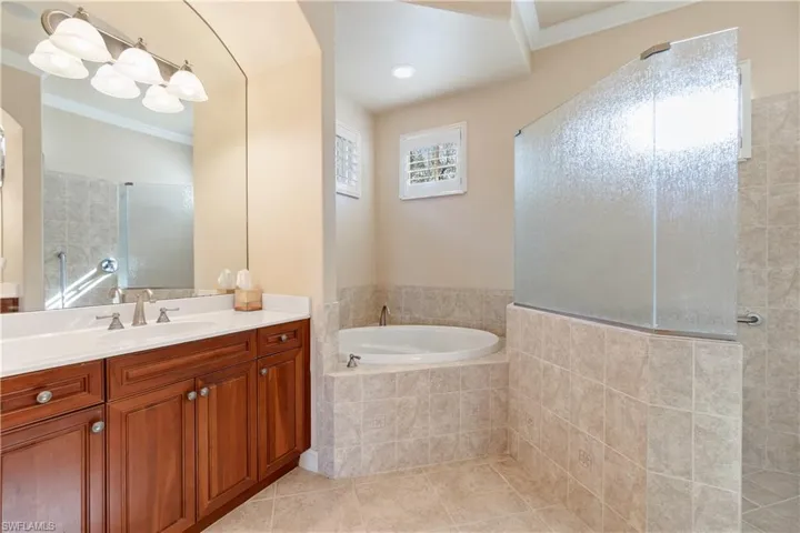 Bathroom featuring vanity, ornamental molding, a wealth of natural light, and tile patterned flooring