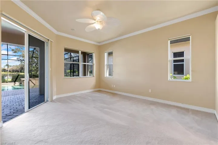 Carpeted spare room with crown molding and ceiling fan