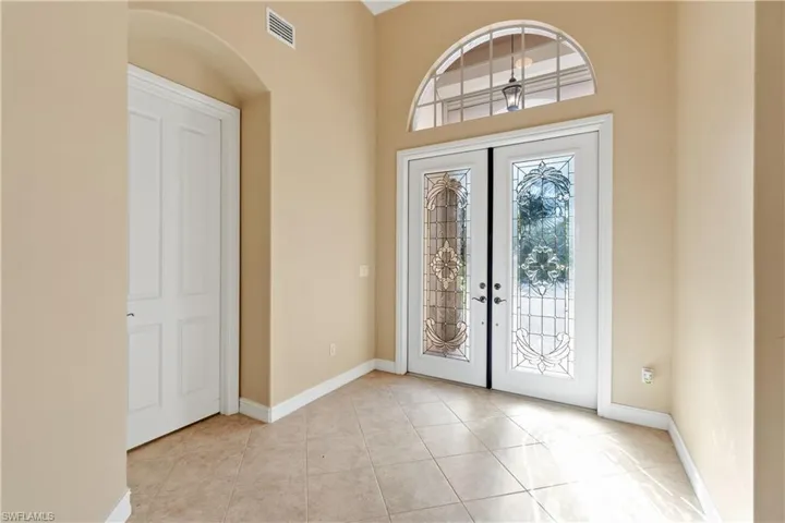 Foyer with french doors and light tile patterned flooring