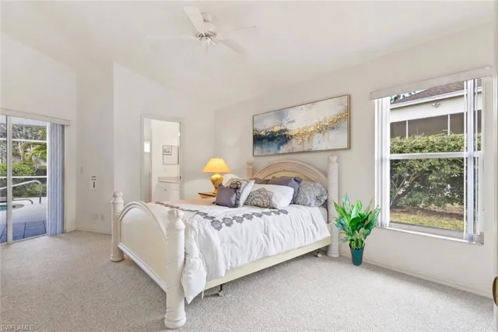 Carpeted bedroom featuring access to outside, ceiling fan, and lofted ceiling