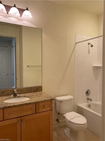 Bathroom with vanity, light tile patterned floors, and  shower combination