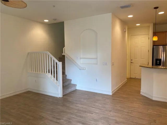 Staircase with wood finished floors and recessed lighting