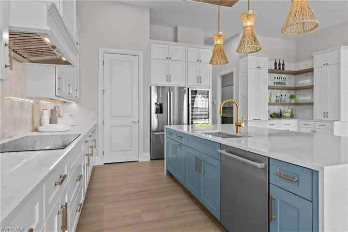 Kitchen featuring blue cabinets, wine cooler, white cabinets, and appliances with stainless steel finishes