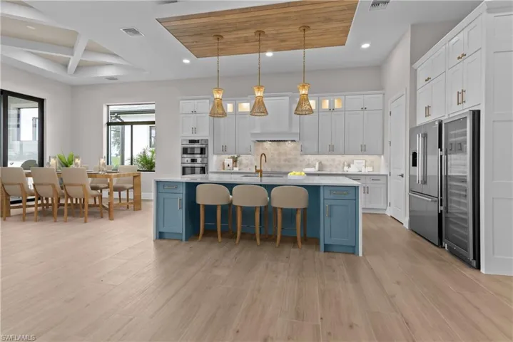 Kitchen with recessed lighting, high quality fridge, backsplash, blue cabinetry, and light countertops