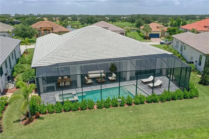 View of swimming pool with a patio, a lawn, outdoor lounge area, a pool with connected hot tub, and a residential view
