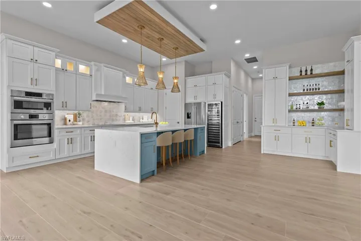 Kitchen with open shelves, light countertops, tasteful backsplash, white cabinets, and pendant lighting