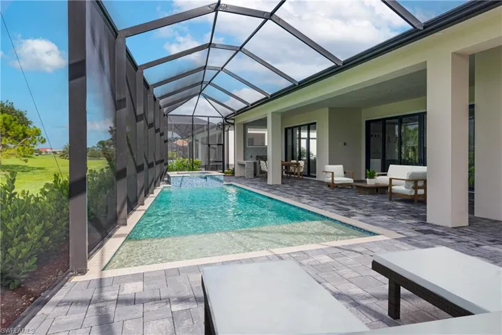 View of swimming pool with a patio area, a pool with connected hot tub, and a lanai