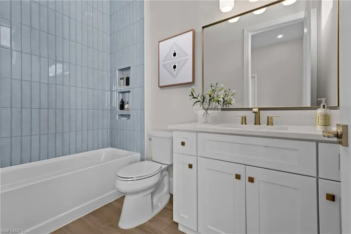 Full bath featuring vanity, wood finished floors, and bathing tub / shower combination