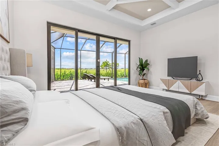 Bedroom with beamed ceiling, access to exterior, coffered ceiling, wood finished floors, and a sunroom
