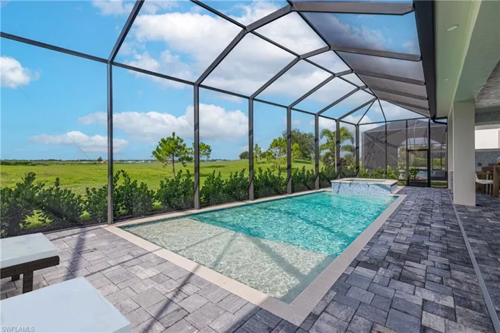 View of pool with a patio, a pool with connected hot tub, and a lanai