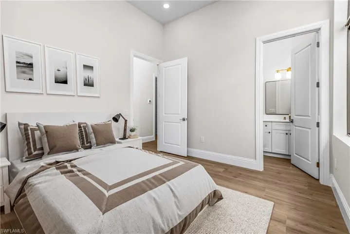 Bedroom featuring light wood finished floors, recessed lighting, and ensuite bathroom