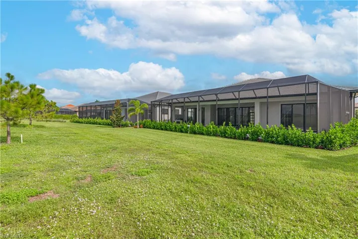 View of grassy yard featuring a lanai and a residential view