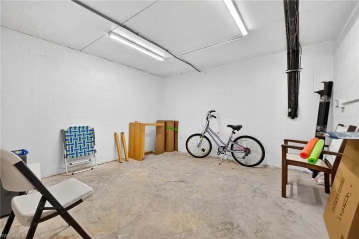 Storage room featuring concrete flooring and concrete block wall