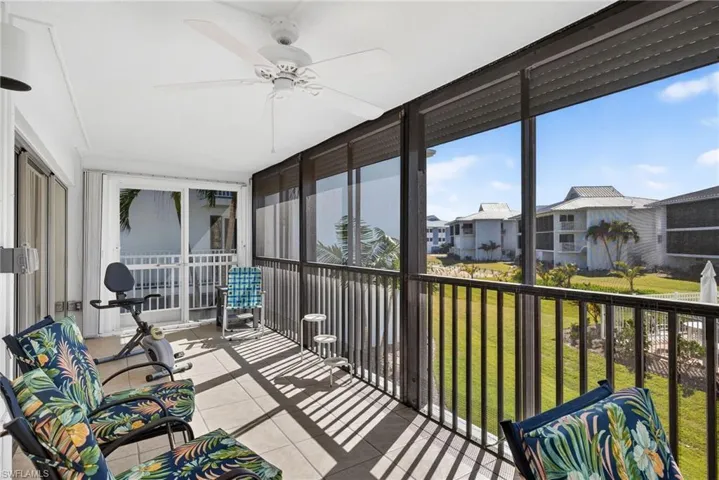 Sunroom featuring ceiling fan and a balcony