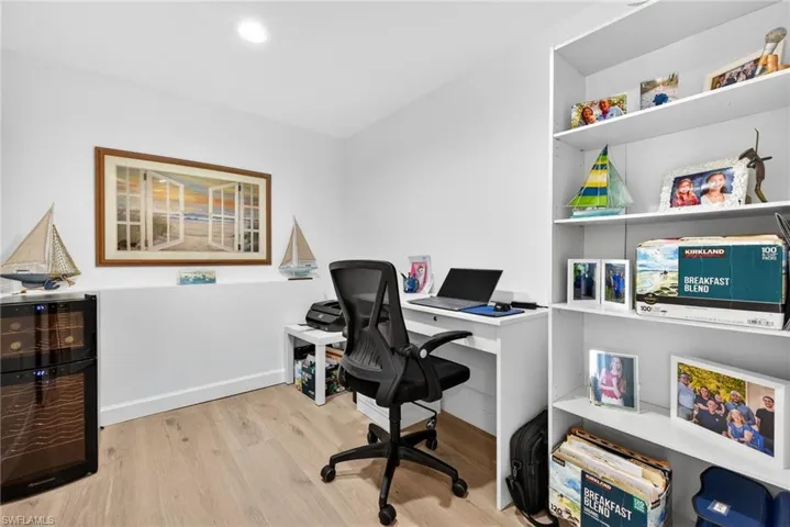 Office featuring beverage cooler and light wood finished floors