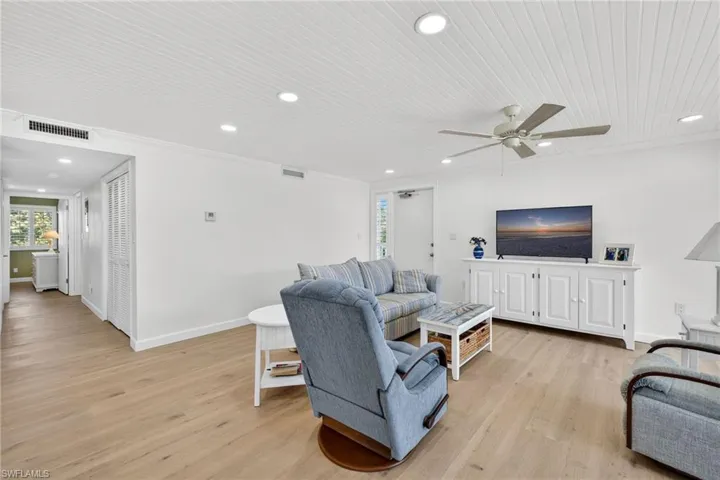 Living area featuring light wood finished floors, ceiling fan, recessed lighting, and crown molding
