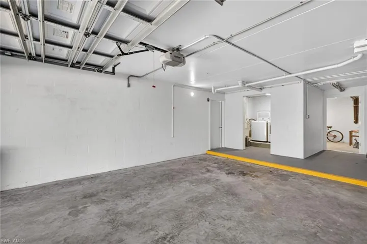 Garage with a garage door opener and washer and clothes dryer