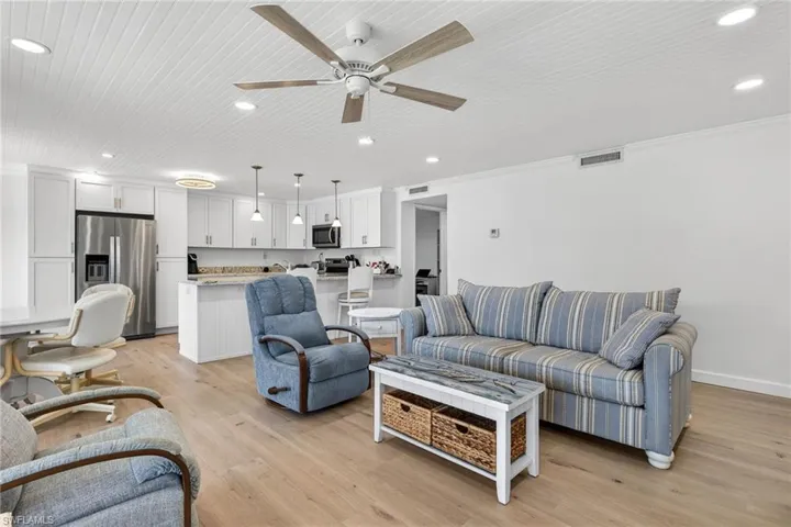 Living area featuring ceiling fan, recessed lighting, light wood finished floors, and crown molding