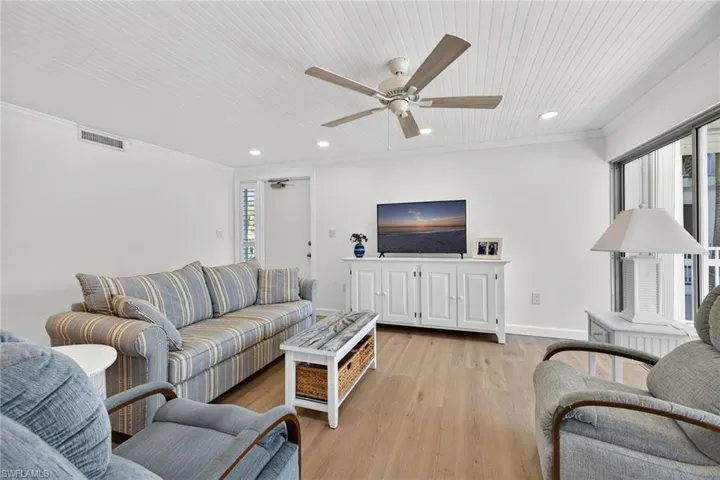 Living area featuring light wood finished floors, recessed lighting, a ceiling fan, and ornamental molding