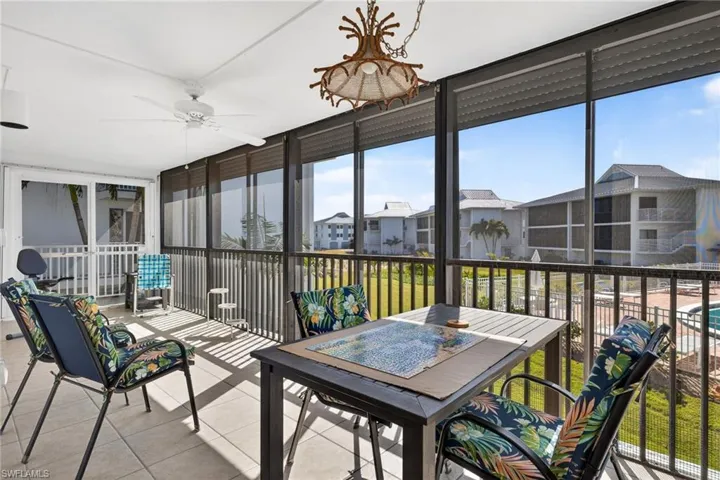 Sunroom featuring healthy amount of natural light, ceiling fan, and outdoor dining space