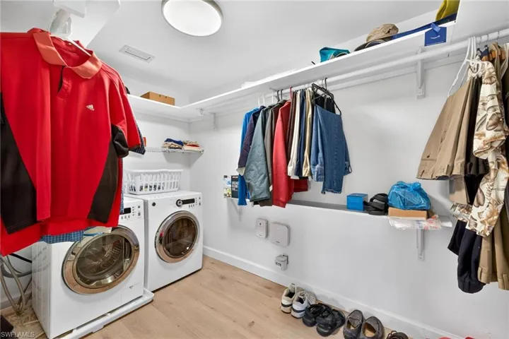 Primary Closet & Laundry area with light wood-style flooring and washing machine and dryer