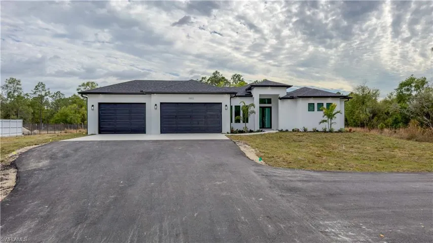Prairie-style house featuring stucco siding, driveway, and an attached garage