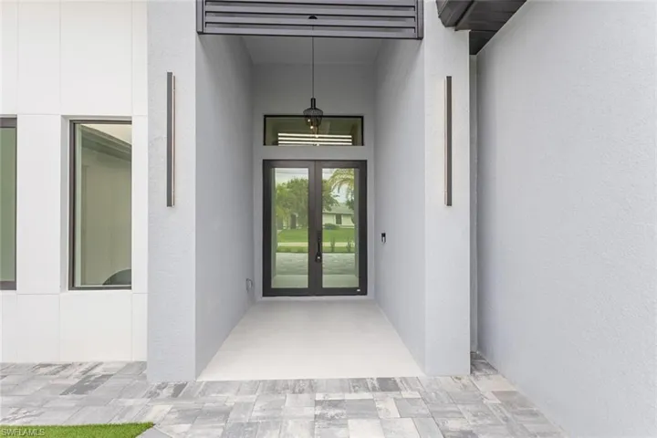 Doorway to property featuring a patio area, french doors, and stucco siding