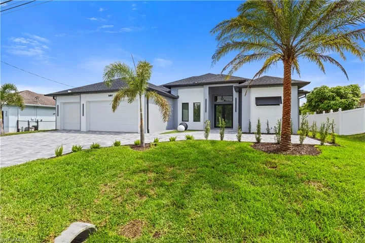 View of front of property featuring an attached garage, stucco siding, decorative driveway, and roof with shingles