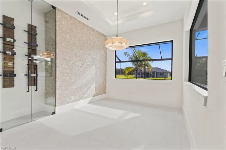 Unfurnished dining area with tile patterned flooring and a raised ceiling