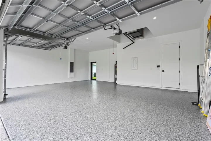 Garage featuring electric panel and a garage door opener