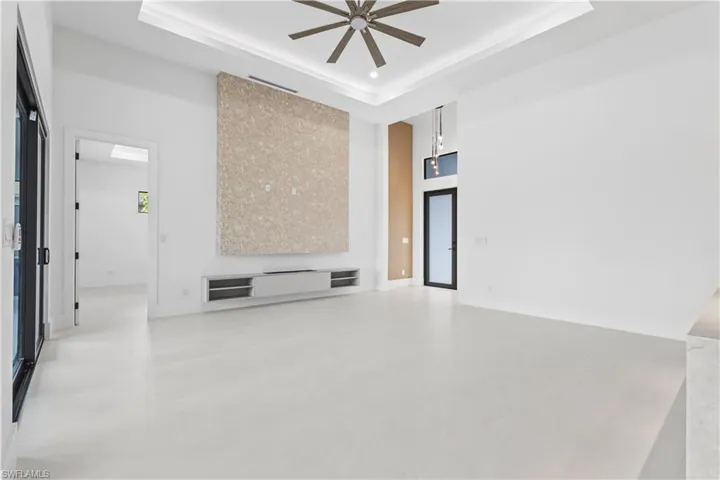 Spare room with a raised ceiling, a towering ceiling, and a ceiling fan