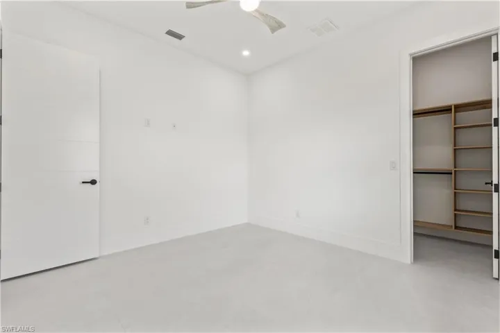 Unfurnished bedroom featuring a spacious closet, a ceiling fan, recessed lighting, and light tile patterned floors