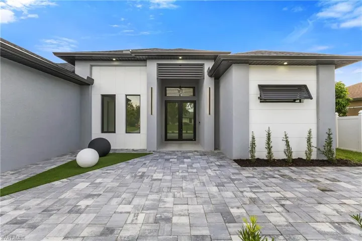 Doorway to property featuring stucco siding and french doors