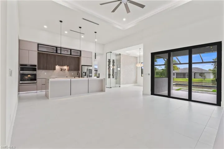 Unfurnished living room with a high ceiling, recessed lighting, and light tile patterned floors
