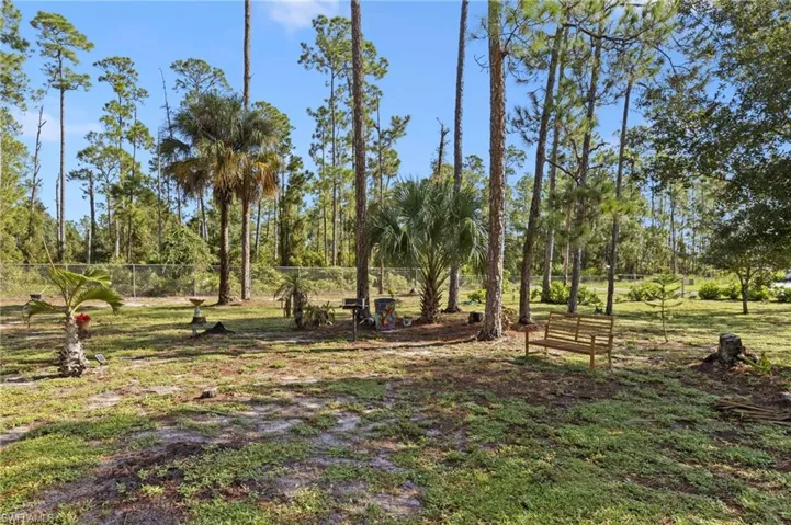 Enormous chain link fenced 1 acre yard space located on a dead end road with tons of mature trees and second gate access with driveway culvert