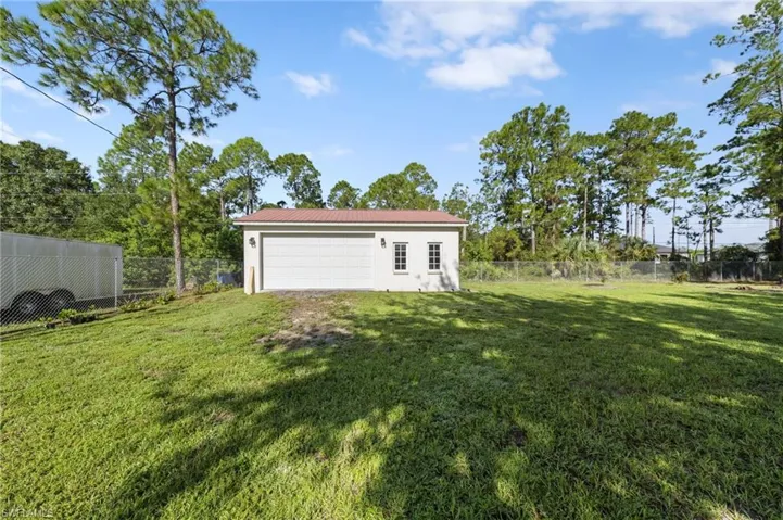 Detached 24'x40' 3 car garage/workshop with a metal roof, 30 amp service, front facing and side load garage doors, bright overhead work lights, fans for circulation, epoxy coated floors, tons of outlets throughout for running tools